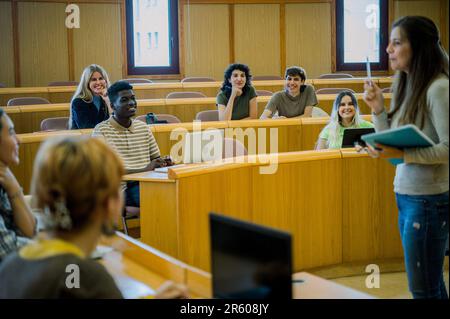 Group of smiling students sitting in classroom Stock Photo