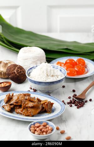 Ingredient Making Zongzi, Chinese Rice Dumpling Bakcang for Dragon Boat Festival Celebration. Bamboo Leaf, Salted Egg, Chicken, Garlic, Onion, and Ric Stock Photo