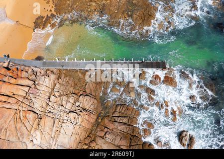 Aerial view of a small jetty in a rocky inlet at Cape Conran, Gippsland, Victoria, Australia. Stock Photo