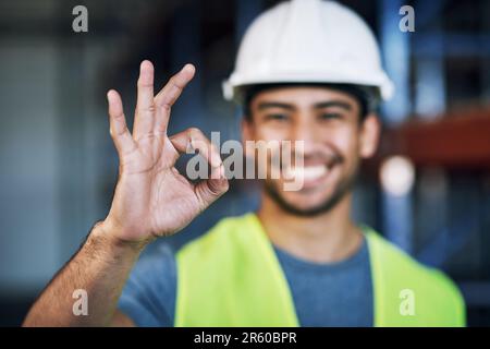 Happy man, architect and hands with okay sign for construction success or good job on site. Hand of male person, engineer or contractor showing OK Stock Photo