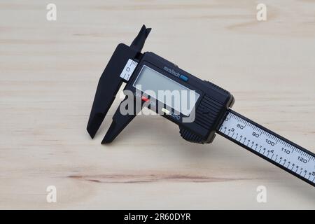 A close-up image of a digital electronic caliper, showing its stainless steel body, digital display, and its precise measuring capability Stock Photo
