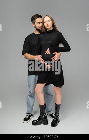 Bearded man hugging wife on white background Stock Photo - Alamy