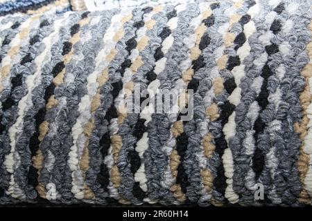 Close-up of a multi-colored striped carpet with thick woven loops. Features a vibrant mix  blue, grey, brown, and white tones. Stock Photo