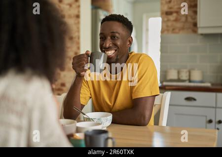 Smiling African man talking with his wife over coffee at breakfast Stock Photo