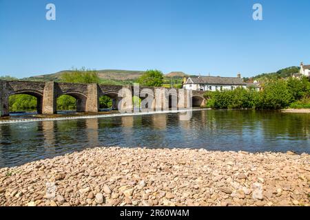 The river Usk flowing under the ancient Crickhowell Bridge in the South Wales town of Crickhowell Powys, with Table mountain rising above the town Stock Photo