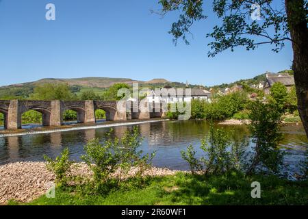 The river Usk flowing under the ancient Crickhowell Bridge in the South Wales town of Crickhowell Powys, with Table mountain rising above the town Stock Photo