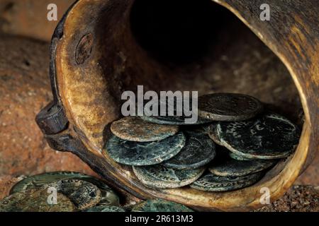 A closeup shot of ancient Roman coins coming out of a cornucopia. Stock Photo