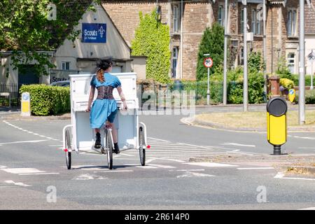 Chloe Marie Aston, a busker in the South West of England riding her unique Piano Bike from one location to another. Stock Photo