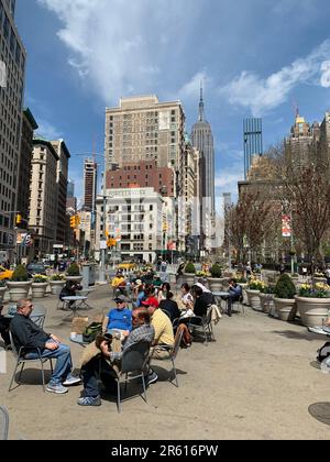 Friends enjoy an outdoor cafe in New York City on a warm sunny spring day Stock Photo