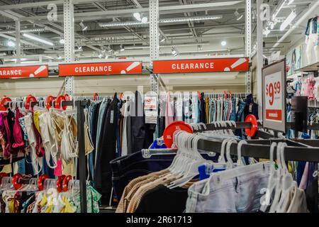 Crowded clearance section in a clothing store, with various