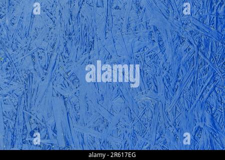 Blue paint chipboard abstract pattern surface pressed wood plywood texture particleboard background. Stock Photo