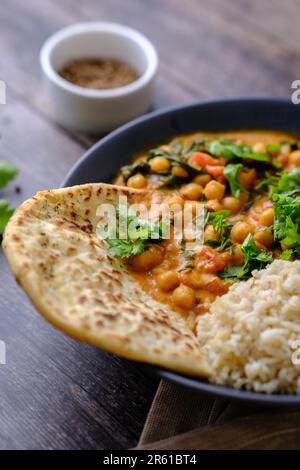 Vegan Chickpea Curry on a dark background. Close-up. Healthy vegetarian food concept. Traditional Indian food concept. Stock Photo