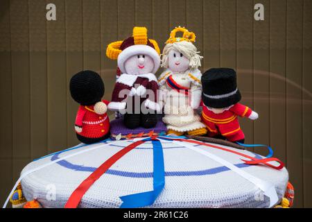 A knitted pillar box topper celebrating the coronation of King Charles III.  In Snettisham, Norfolk. Stock Photo