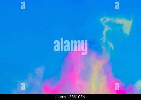 Multicolored bright powder festival colors holi color abstract background blue sky. Stock Photo