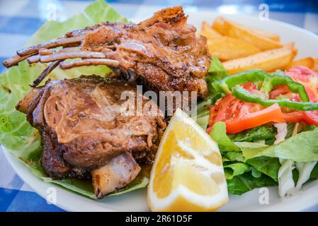 Juicy oven-baked lamb ribs infused with traditional Greece herbs and spices, flavorful and succulent Greek culinary experience. Stock Photo