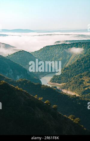 An aerial view of a majestic mountain shrouded in mysterious clouds and ...