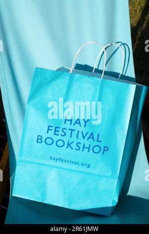 Turquoise Hay Festival Bookshop carrier bag on blue canvas deckchair background at Hay Festival 2023 in Hay-on-Wye Wales UK Stock Photo