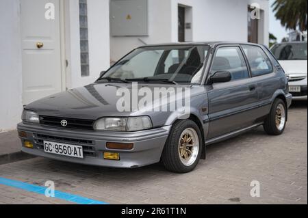 A classic Japanese car, the small Toyota Corolla XL EE90 in gray color parked in the street Stock Photo