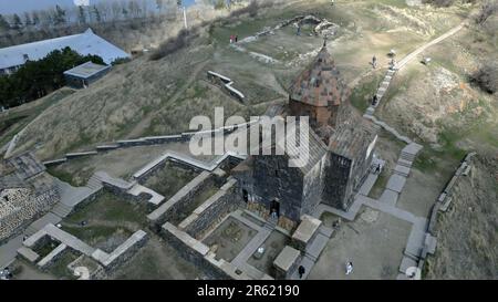 Sevanank Monastery Complex in Armenia. Monastery buildings with crosses, view from above, against the background of Lake Sevan, houses, people, high s Stock Photo