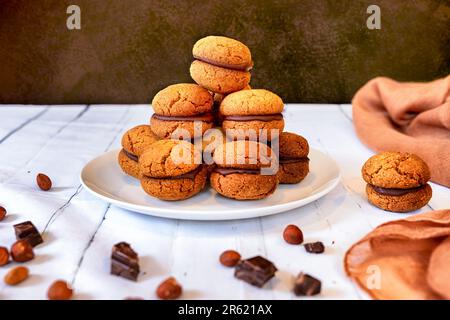 An assortment of freshly baked sandwich cookies on a white plate Stock Photo