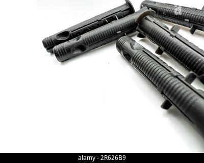 A close-up image of four black rifles with rubber grips and black blades placed on a white surface Stock Photo