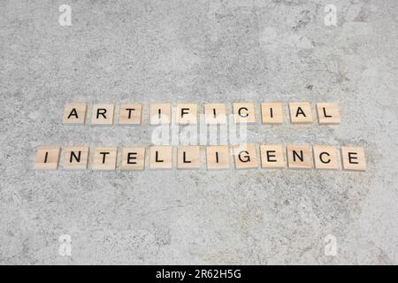 Wooden letter blocks spelling out Artificial Intelligence against marble stone as an AI explanation concept Stock Photo