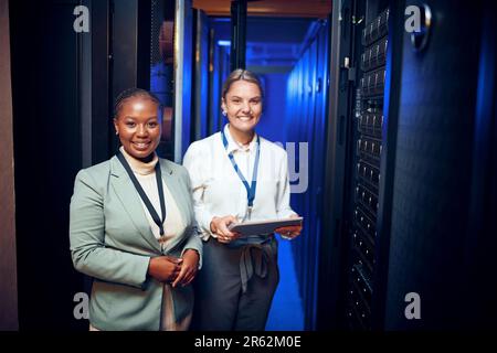 Make way for the tech gurus. Portrait of two technicians using a digital tablet while working in a server room. Stock Photo