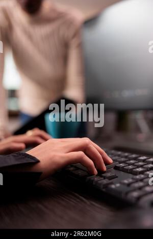 Team of programmers typing machine learning html code on computer, sitting at desk table in it security agency. Diverse system engineers working on database system with html script. Close up Stock Photo
