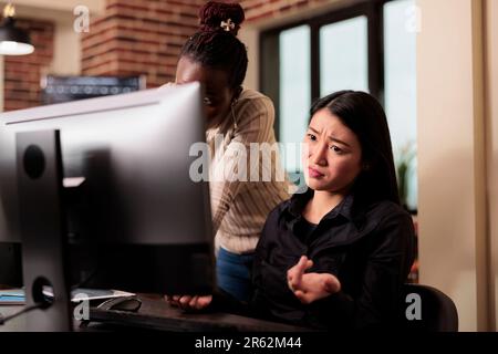 Thoughtful engineers brainstorming ideas to write code and create security program, displaying artificial intelligence algorithm. Pensive software developers thinking about database cloud computing Stock Photo