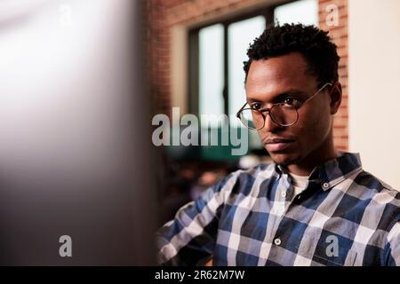 System engineers working with javascript code on terminal window, looking at computer screen and typing. IT software developer writing ai algorithm and sitting at desk in programming company. Stock Photo