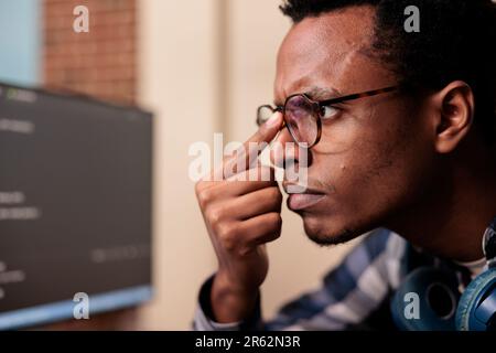 Software developer typing machine learning server code on computer, sitting at desk in software company. Programming engineer working on database system with coding script in it agency Stock Photo
