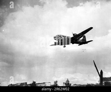 A Douglas C-54 Skymaster dropping candy over Berlin, c. 1948/49 during the Brelin Airlift. In response escalating tensions and to the establishment of.a new West German currency, the Soviets cut off all land communications to West Berlin and stopped sending food there. TheAllied response was an eleven month campaign to supply W Berlin with the 5000 tons per day of food and fuel it needed. A plane landed every three minutes day and night and the operation was so succesful that the Soviets had to back down and reopen the roads, railways and canals. Stock Photo