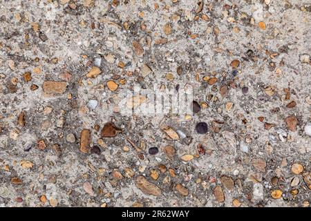 Small brown pebbles in concrete textured background Stock Photo
