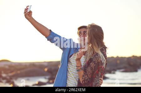 Beach selfies with bae. an happy young couple taking selfies at the beach. Stock Photo