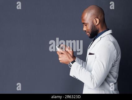 Digital business dealings. Studio shot of a businessman using a digital tablet against a gray background. Stock Photo