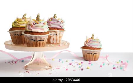 Dessert stand with cute sweet unicorn cupcakes isolated on white Stock Photo
