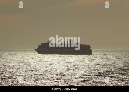 Oosterdam, a Holland American line Vista class cruise ship departs the Italian port of Civitavecchia, Italy as sunset commences, April 2023. Stock Photo