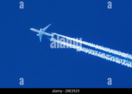 Sharp telephoto close up of jet plane aircraft with contrails cruising