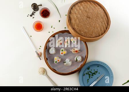 Yumcha, Dim Sum in Bamboo Steamer with Chilli Oil and Dumpling Sauce. Top View, Copy Space for Text Stock Photo