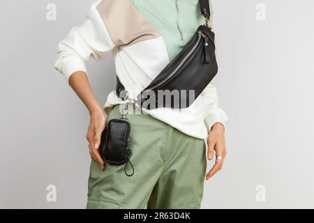 Small Leather Case for Electronic Cigarette Attached to the Waist and Genuine Leather Fanny on the Female Model over Gray Background, Studio Shot Stock Photo