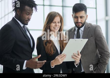 Diverse staff members confident smile business team holding document notepad device Stock Photo