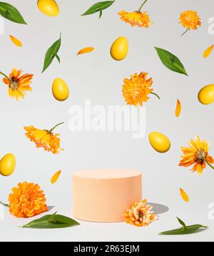 Geometric podium platform stand for product presentation, Easter eggs and levitate spring flowers on grey background. Mock up scene. Business Concept. Stock Photo