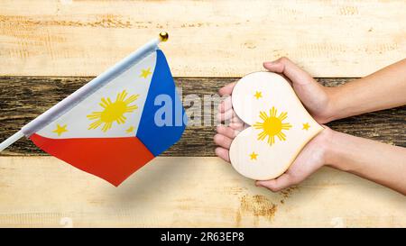 A human hand is holding a heart with the Philippine flag color. Philippines Independence Day concept Stock Photo