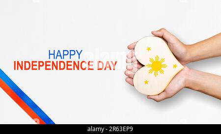 A human hand is holding a heart with the Philippine flag color. Philippines Independence Day concept Stock Photo