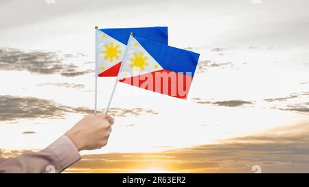 A human hand holding a Philippine flag. Philippines Independence Day concept Stock Photo