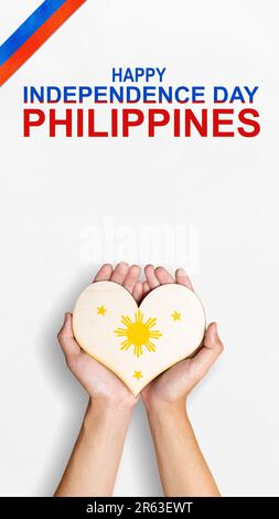 A human hand is holding a heart with the Philippine flag color. Philippines Independence Day concept Stock Photo