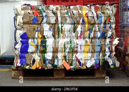 colorful recycled card board packaging paper bale. pressed and flattened boxes bound in tight cube shape. recycle, reuse, reduce concept. environment Stock Photo