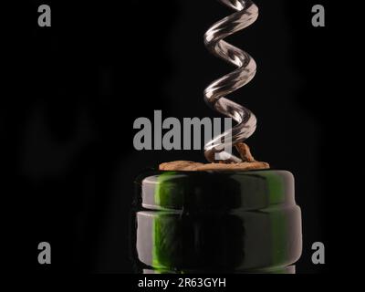 Close uo of a wine bottle with bottle opener on a dark background Stock Photo