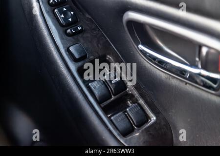 Close-up of the side door buttons: window adjustment buttons, door lock. Window control panel in a modern car. Automatic car window controls and detai Stock Photo