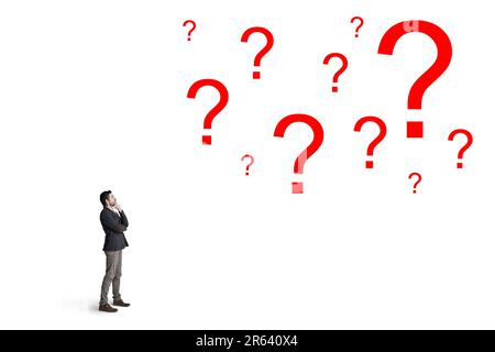 Ask the right questions before you invest. a businessman looking up at question marks against a white background. Stock Photo